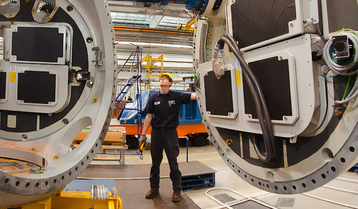 Man connecting two large machine pieces.
